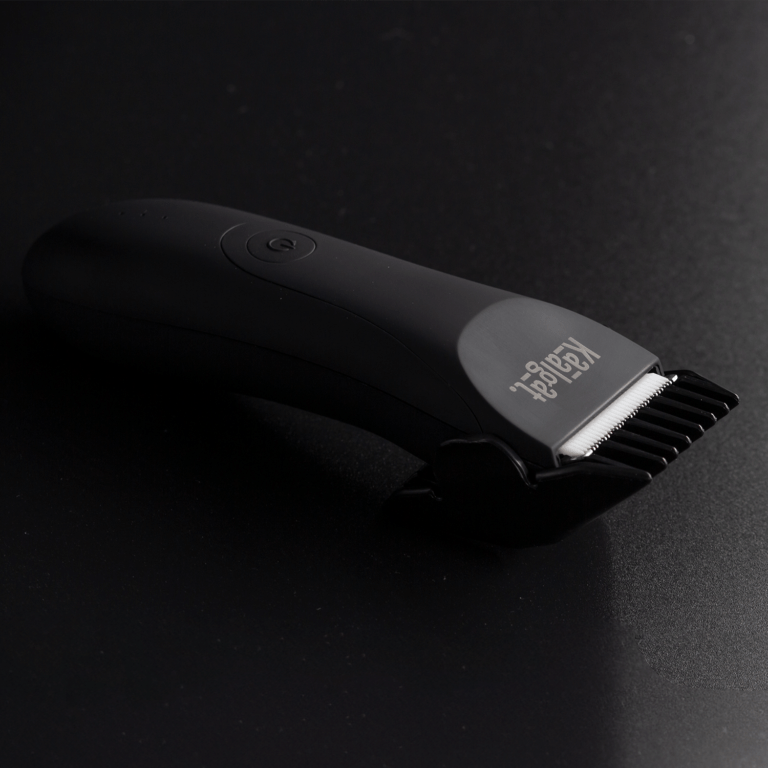 Isometric view of the rechargeable electric Kaalgat Body Groomer with a positioning comb installed for variying hair lengths